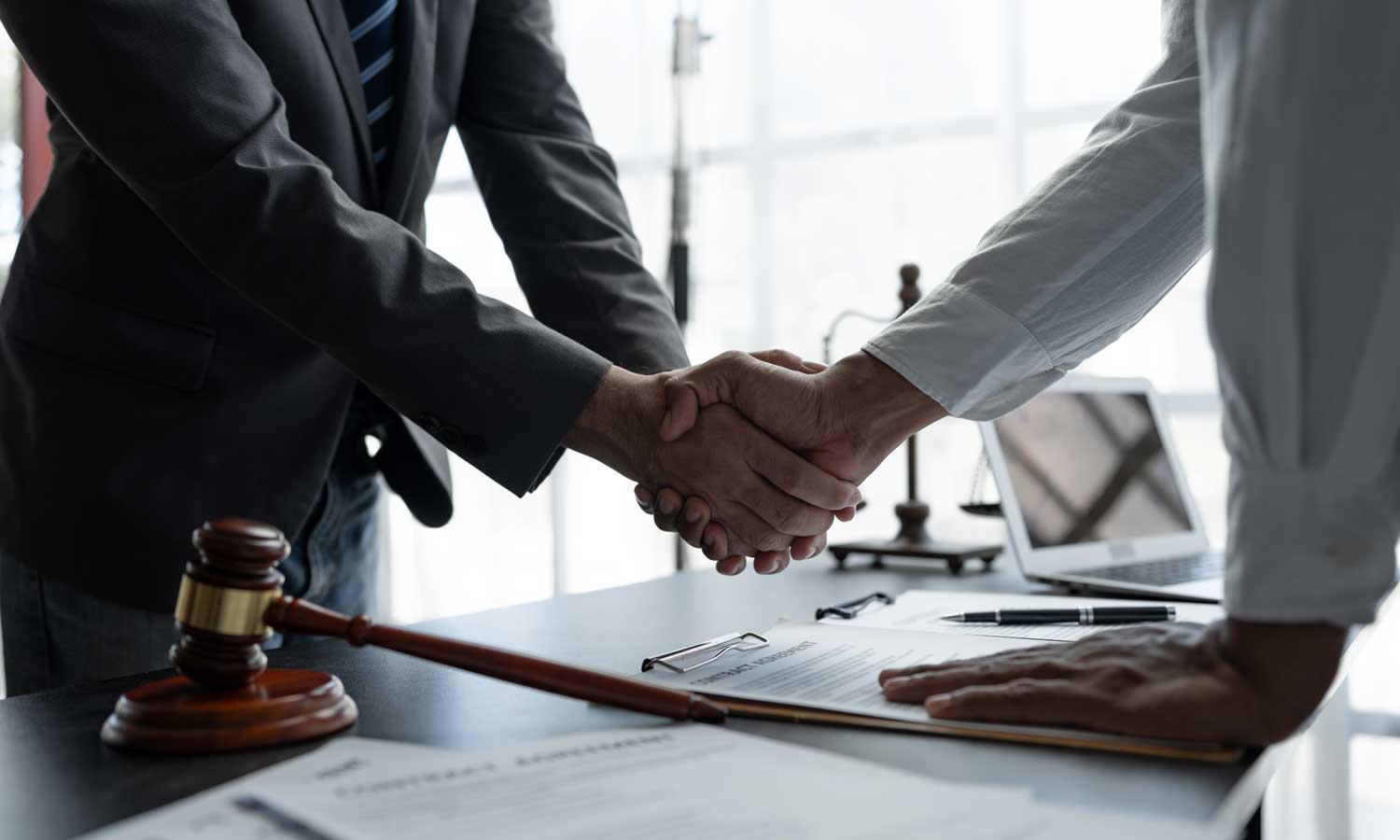 Attorney and client shaking hands after agreeing to contingency fee representation for a will contest